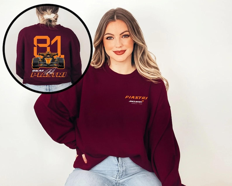 May include: Burgundy sweatshirt featuring the name "PIASTRI" in orange, with the McLaren logo below. The back of the sweatshirt displays the number "81" and a race car graphic in orange and black, with "OSCAR PIASTRI" below.