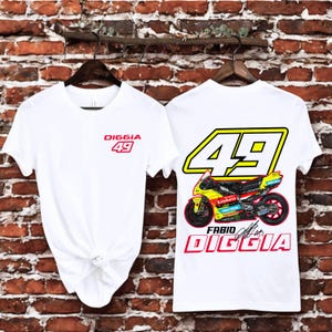 May include: White t-shirts with a motorcycle racing design. One shirt has "DIGGIA 49" in red on the front. The other shows a motorcycle graphic with "49" and "FABIO DIGGIA" in red, yellow, and black.
