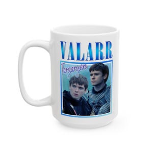 以下が含まれることがあります： 「VALARR Targaryen」の文字と2人の男性が描かれた、青と白のグラフィックが特徴の白いセラミックマグカップ。マグカップには大きなハンドルとまっすぐな円筒形があります。画像はファンアートのデザインです。