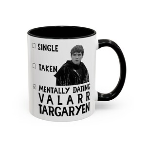 May include: White ceramic mug with a black interior and handle. The mug features the text "SINGLE", "TAKEN", and "MENTALLY DATING VALARR TARGARYEN" with a black and white image of a person.