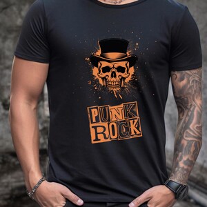 Peut inclure: T-shirt noir avec un crâne orange portant un chapeau haut de forme et l'inscription "PUNK ROCK" en orange. Le motif comprend un effet d'éclaboussure orange. Le t-shirt est à col rond.