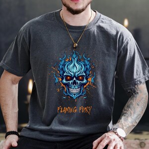 May include: Dark grey t-shirt with a blue flaming skull graphic and orange accents, with the text "Flaming Fury". The design features a detailed skull with blue flames. This is a casual wear item.