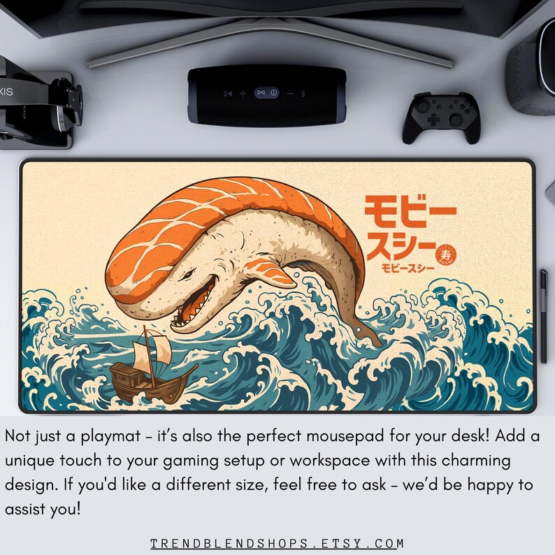 May include: A rectangular playmat featuring a whimsical design of a sushi-whale in a sea of waves. The sushi-whale has orange and white coloring. Japanese text is visible. The playmat is designed for gaming or workspace use.