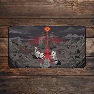 Puede incluir: Alfombrilla de escritorio rectangular con una ilustración de dibujos animados de gatos en un paisaje de fantasía. La escena incluye un castillo oscuro, un ojo llameante y varios gatos en un terreno rocoso, con una combinación de colores gris oscuro y rojo.