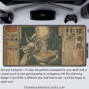 May include: A rectangular playmat with a vintage-style illustration of a creature eating noodles, with Japanese text. The playmat is designed for gaming setups and workspaces. The image has a beige and brown color scheme.