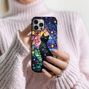 May include: A black cat with a galaxy pattern in a stained glass style on a phone case. The case is black and has a rainbow color scheme.