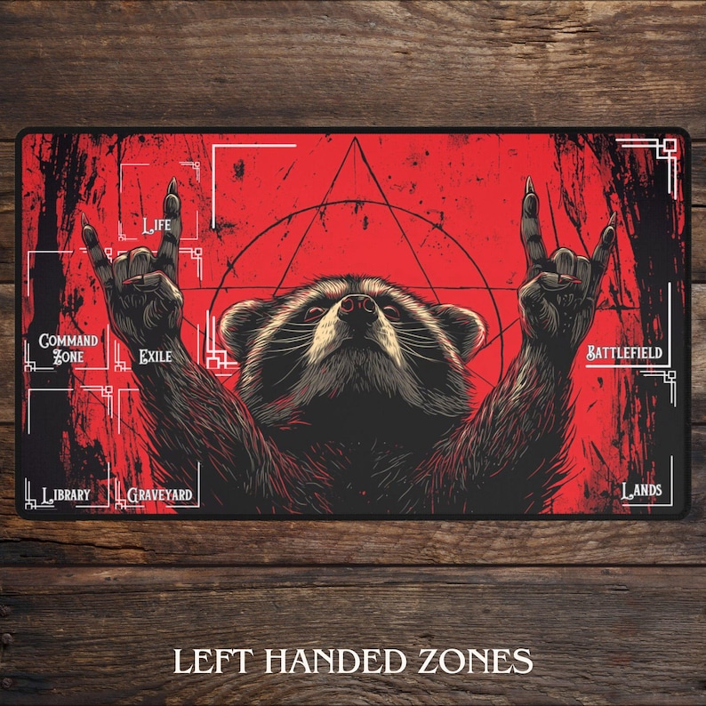 Peut inclure: Tapis de jeu rouge et noir avec un raton laveur levant les bras en signe de rock. Le tapis comporte des zones &eacute;tiquet&eacute;es "Vie", "Exil", "Champ de bataille", etc. Le texte "Zones gauch&egrave;res" est en bas.