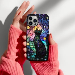 May include: A black cat silhouette in a stained glass style design with a galaxy background. The phone case is black with a clear protective layer over the design.