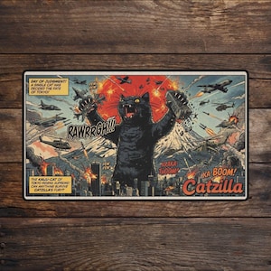 Può includere: Un cartello metallico rettangolare con un'illustrazione in stile fumetto di un gatto nero gigante che distrugge una città. Il gatto ruggisce con il testo "RAWRRGH!!!" sopra. Il cartello recita "Catzilla" e "Giorno del giudizio! Un singolo gatto ha deciso il destino di Tokyo!"