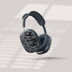 Puede incluir: Auriculares circumaurales de color gris oscuro con un diseño de cómic. Los auriculares presentan un patrón en blanco y negro con bocadillos y palabras de acción como "POW!" y "OMG!". La diadema y los auriculares son de color gris oscuro liso.