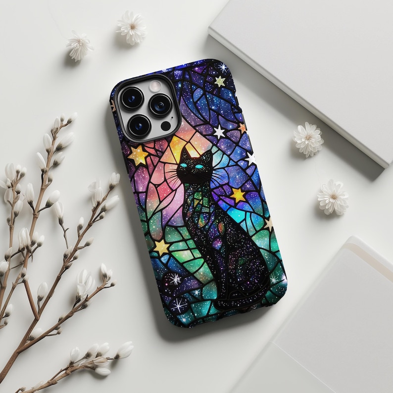 Elevate your iPhone 16 with this striking phone case featuring the Stained Glass, a black cat with bright blue eyes, and a vibrant starry background in stained glass style. This intricate design adds personality and protection.