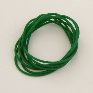 May include: A bundle of green rubber bands, tightly wound together.