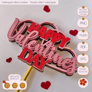 Puede incluir: Un topper de pastel de capas rojo y rosa con las palabras "Happy Valentine's Day" en un estilo de capas con efecto de sombra. El topper está en un palo dorado e incluye una descarga digital del diseño en formatos PNG, Studio, PDF y SVG.