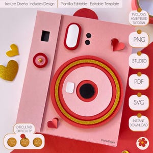 Puede incluir: Cámara de papel rosa y roja con detalles de purpurina dorada. La cámara es un modelo 3D con un objetivo emergente y un corazón en el lateral. La imagen incluye el texto "DIFICULTAD DIFFICULTY" y "BAJA MEDIA ALTA LOW HALF HIGH".