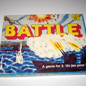 May include: A vintage board game box with a blue background and a colorful illustration of a plane, a submarine, and an explosion. The box says "BATTLE" in large yellow letters and "A game for 2. Un jeu pour 2." in smaller letters.