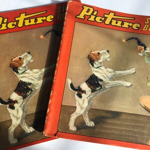 May include: Two vintage red Picture Story Book covers featuring a black and white fox terrier jumping for a ball. The cover on the left has the text "Picture Story Book" in black letters. The cover on the right has the text "Picture Story Book" in black letters.