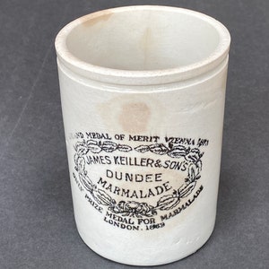 May include: White ceramic jar with a black and white label that reads "AND MEDAL OF MERIT VIENNA 1873 JAMES KEILLER & SON'S DUNDEE MARMALADE ONLY PRIZE MEDAL FOR MARMALADE LONDON. 1889".