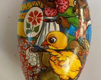 May include: A vintage Easter egg shaped box with a colorful illustration of a rabbit, a chick, and a squirrel painting Easter eggs. The box is made of paper mache and has a glossy finish.