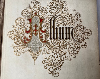 May include: An antique album cover with a decorative gold and red design. The word "Album" is written in a fancy script.