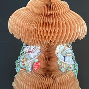 May include: A vintage Valentine's Day card with a honeycomb paper construction. The card features two girls in dresses holding flowers and a heart with the word "Love" on it.