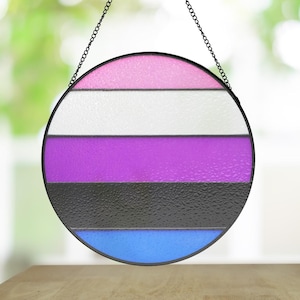 May include: A round, stained glass window hanging with a chain. The window is divided into five horizontal stripes of pink, white, purple, black, and blue.