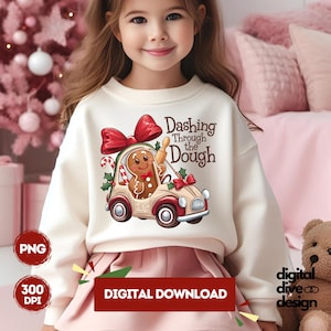 May include: A white sweatshirt featuring a gingerbread man driving a car with the text "Dashing Through the Dough".