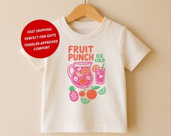 Könnte beinhalten: Cremefarbenes Kinder-T-Shirt mit einem Fruchtpunsch-Motiv. Das Design zeigt einen rosa Krug, ein Glas eiskalten Punsch und verschiedene Früchte. Der Text "FRUIT PUNCH ICE COLD" ist über der Grafik aufgedruckt.