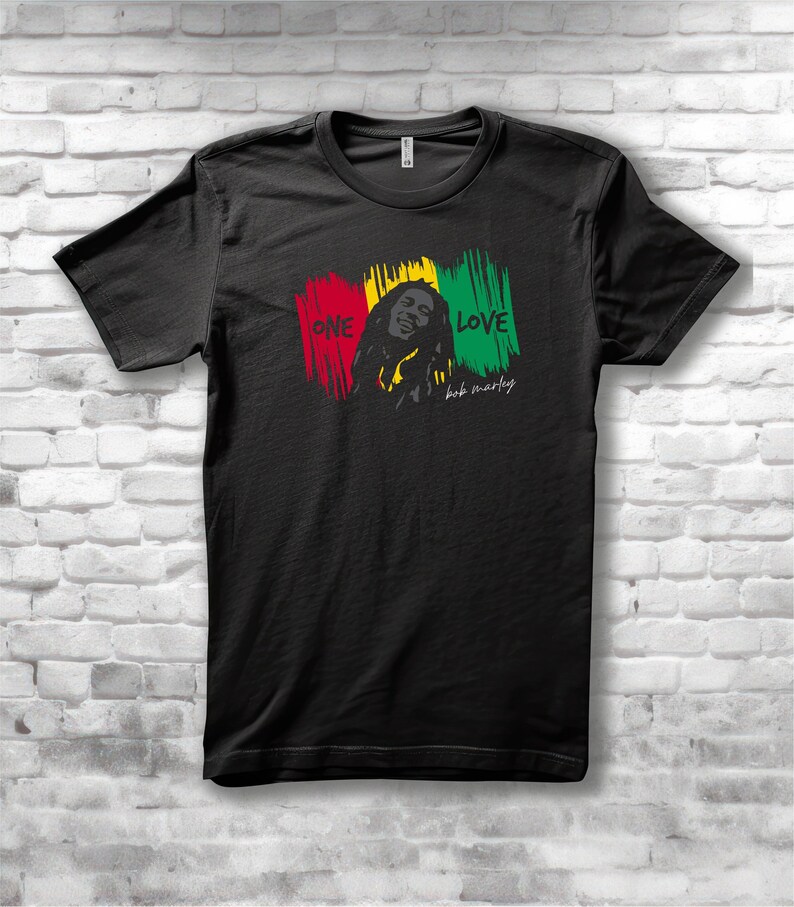 May include: Black t-shirt featuring a graphic of Bob Marley with the words "ONE LOVE" in red, yellow, and green brushstrokes. The design includes a portrait of Bob Marley and his signature.