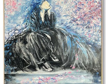 May include: Abstract painting of a person in a black dress and sneakers, seated and looking up. The background features blue and pink brushstrokes, suggesting a floral or natural setting. The artwork is framed in a gold-colored square frame.