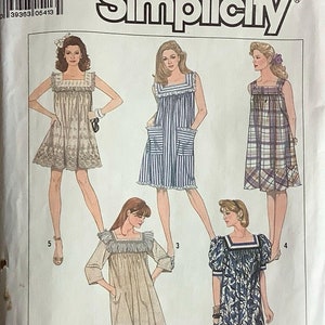Op de afbeelding: Een naaipatroon voor een jurk met vijf verschillende stijlen. Het patroon is van Simplicity en de maat is SM. De jurkstijlen omvatten een jurk met korte mouwen met een ruche-bies, een jurk zonder mouwen met zakken en een jurk met lange mouwen met een ruche-bies.