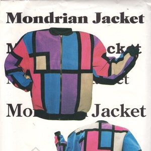 Könnte beinhalten: Eine Jacke mit einem geometrischen Muster in Schwarz, Weiß, Rosa, Blau und Lila. Die Jacke hat einen Reißverschluss und einen Stehkragen. Der Text "Mondrian Jacket" ist auf dem Bild gedruckt.