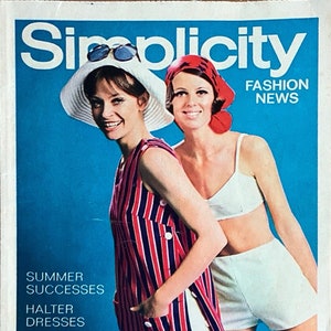 May include: A vintage Simplicity magazine cover featuring two women modeling summer fashion. The cover features the text "Simplicity Fashion News" and "Summer Successes, Halter Dresses, Jumpsuits for the Whole Family, Featuring June Patterns".