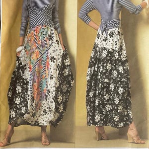 May include: A sewing pattern envelope for a dress featuring a blue and white striped long-sleeve bodice with a wrap-front detail. The skirt is a floor-length, multi-panel design with black and white floral prints and a central panel of colourful floral fabric. The text V2971 and Koos Couture are visible.