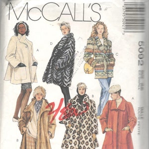 Puede incluir: Patrón de costura McCall's con ilustraciones de varios abrigos y chaquetas. Los diseños incluyen un abrigo color crema, un abrigo con estampado de cebra, un abrigo envolvente estampado, un abrigo largo color canela, un abrigo con estampado de leopardo y un abrigo rojo. El texto "FOCUS ON FAKE FUR" es visible.