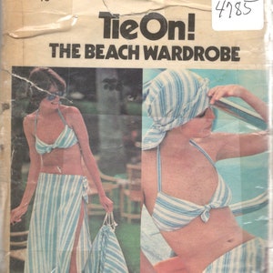 May include: Vintage sewing pattern for a beach wardrobe, featuring a striped bikini top and skirt, and a striped headscarf. The pattern is called "Tie On!" and is number 4785.