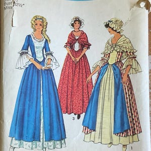 May include: A Simplicity sewing pattern envelope 6787 for Costumes for the Bicentennial, size 10, bust 32.5 inches. The cover features illustrations of three historical-style dresses with ruffled sleeves, bonnets, and shawls in blue, red, and white.