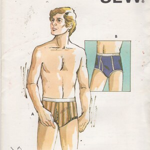 May include: A Kwik Sew pattern envelope for underwear, labeled 722 with waist sizes 26-28 inches. The illustration shows two styles of briefs: style A with brown and tan vertical stripes and style B in solid blue with white trim.