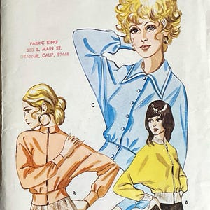 May include: A Kwik Sew pattern envelope 403 for a jacket with dolman sleeves in sizes S, M, L, and XL. The cover features illustrations of three jacket variations in light blue, peach, and yellow, with text including Pattern 403 and Ladies' Dolman Sleeve Jacket.