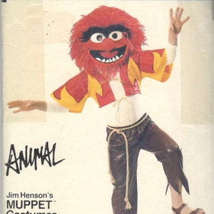 May include: Vogue Patterns 8788 craft pattern for an Animal costume from Jim Henson's Muppet Costumes. The costume features a red furry headpiece, a yellow and red top, brown pants, and sandals. The word "Animal" is written in a stylized font.