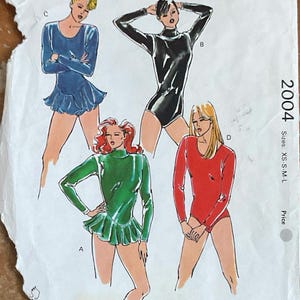 May include: Vintage Kwik Sew pattern 2004 showing illustrations of leotards with long sleeves and a skirted bottom. The pattern includes sizes XS-S-M-L. The cover is slightly torn and shows the Kwik Sew logo.