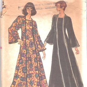 Op de afbeelding: Vintage Vogue Patroon-envelop met illustraties van twee lange jurken. Eén is zwart met witte bies, de andere geel met een bloemen- en geometrisch patroon. De envelop is gescheurd en toont de tekst "Vogue Patterns".