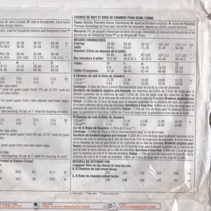 May include: A vintage sewing pattern for a nightgown and robe set, featuring detailed diagrams and measurements. The pattern includes various sizes and fabric suggestions. The image is a close-up of the pattern's front and back.