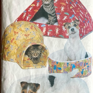 Könnte beinhalten: Ein Schnittmuster für Cozy Critters Haustierbetten. Das Bild zeigt eine Katze in einem roten Zeltbett, einen Hund in einem runden Bett, eine Katze in einem gelben Iglubett und einen Hund auf einem weißen Bett. Das Muster enthält alle Größen.