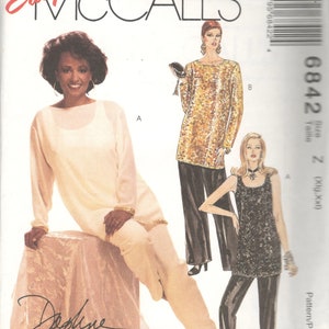 May include: A sewing pattern for three different tops. The pattern is for sizes X-Large and XX-Large. The pattern is from McCall's Easy line and is designed by Topline Maxwell Reid. The pattern includes a white top with long sleeves, a gold sequined top with long sleeves, and a black sequined top with spaghetti straps.