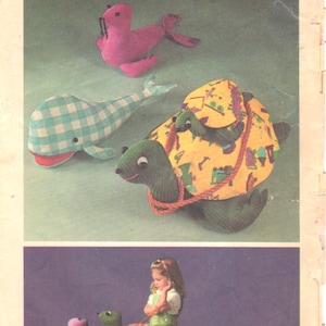 May include: A vintage Simplicity sewing pattern for making stuffed toys. The pattern includes instructions for making a whale, a seal, and a turtle. The pattern is for one size and costs 95 cents. The pattern is illustrated with photos of the finished toys.