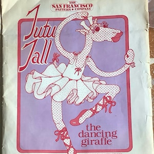 Op de afbeelding: Vintage naaipatroon getiteld "Tutu Tall" met een illustratie van een dansende giraffe. De giraffe draagt een tutu en balletschoenen, met de tekst "the dancing giraffe". Het patroon is voor een giraffe van 116.8 cm. The San Francisco Pattern Company.