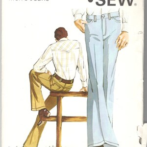 May include: A Kwik Sew pattern envelope for jeans, pattern 410, featuring illustrations of light blue and tan trousers. The text includes Pattern 410, Waist Sizes 30-32-34, Men's Jeans, and Designed by Kerstin Martensson. The paper shows handwritten notes.