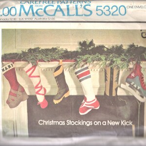 Könnte beinhalten: Ein Vintage-Nähmuster für Weihnachtsstrümpfe in Form von Turnschuhen. Das Muster heißt "Christmas Stockings on a New Kick" und enthält ein Alphabet zur Personalisierung. Das Muster ist von McCall's und trägt die Nummer 5320.