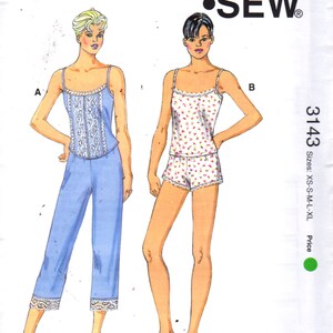 May include: A sewing pattern for a women's pajama top and shorts set. The pattern is called "Kwik Sew" and the pattern number is 3143. The pattern includes two different styles: a top with lace trim and pants, and a top with a floral print and shorts. The pattern is available in sizes XS-S-M-L-XL.