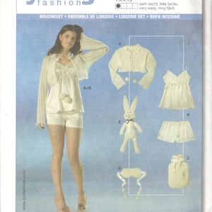May include: A sewing pattern for a white lingerie set with a matching cardigan. The pattern includes instructions for a sleep mask, a hot water bottle cover, and a stuffed bunny. The pattern is labelled "burda young fashion" and has the number 7997.